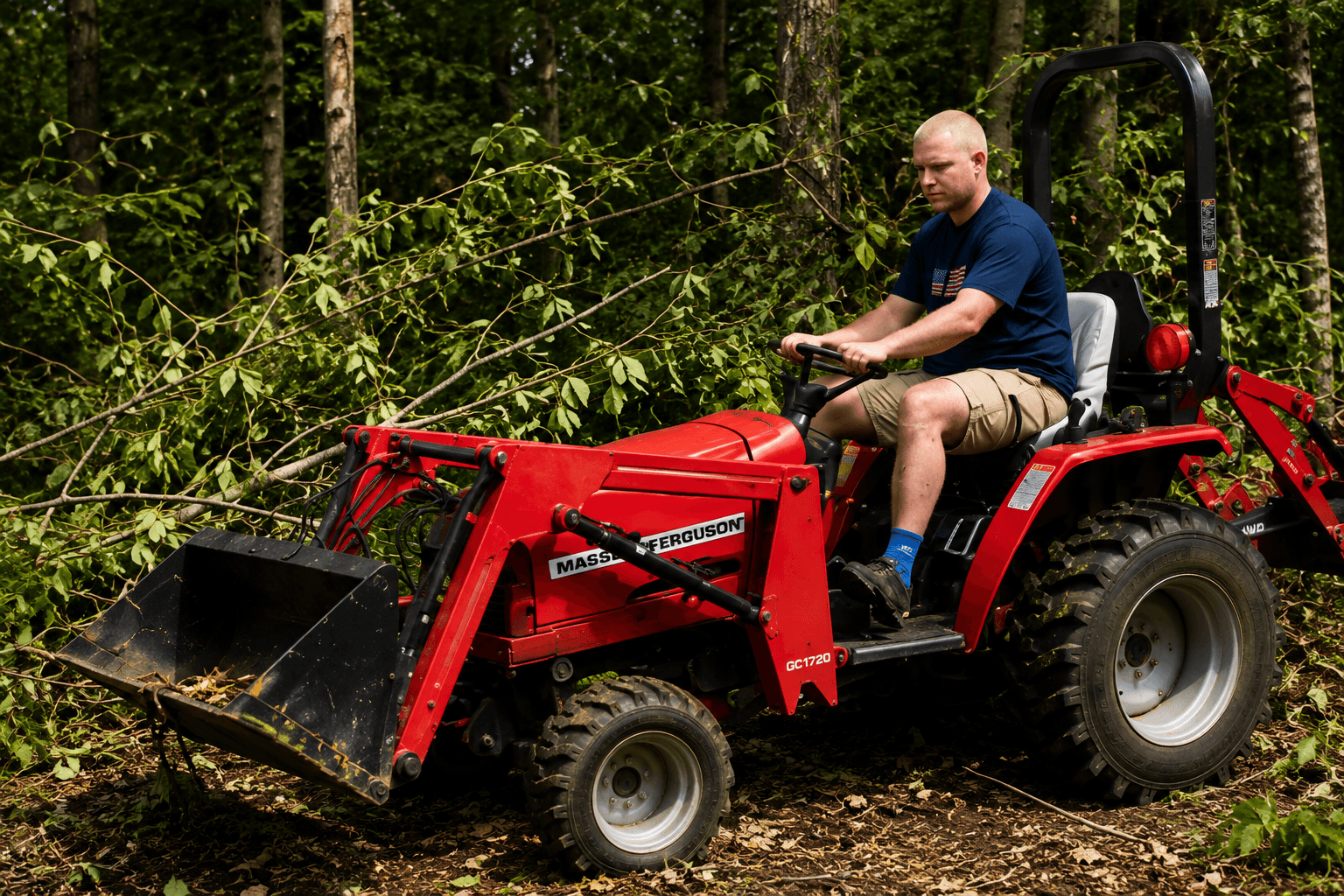 Man operating a red Massey Ferguson tractor with a front loader in a wooded area.